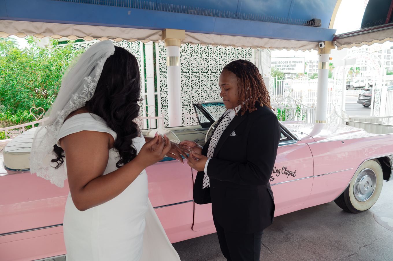 Ring exchange beside the pink Cadillac