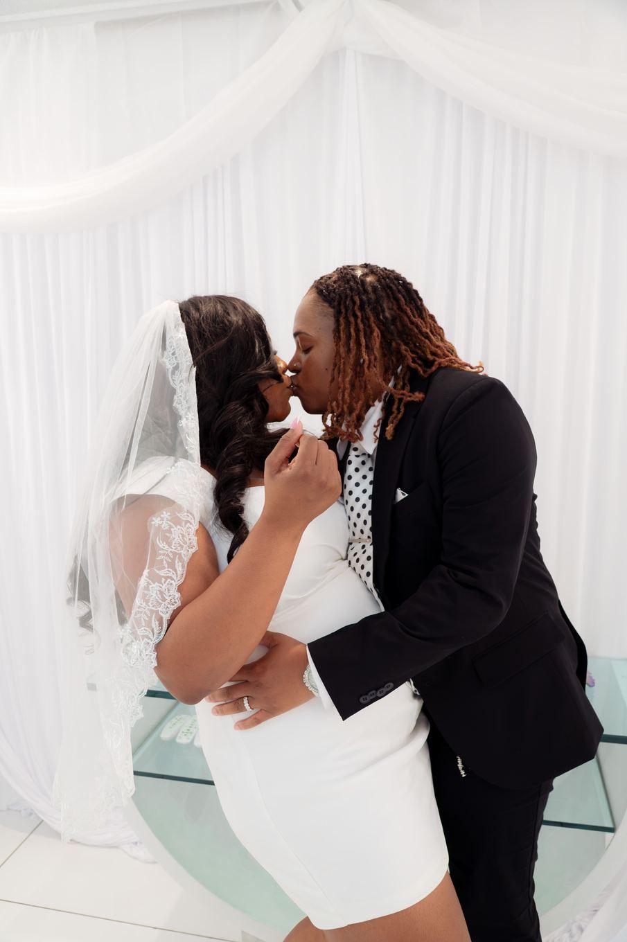First kiss in the white-draped chapel