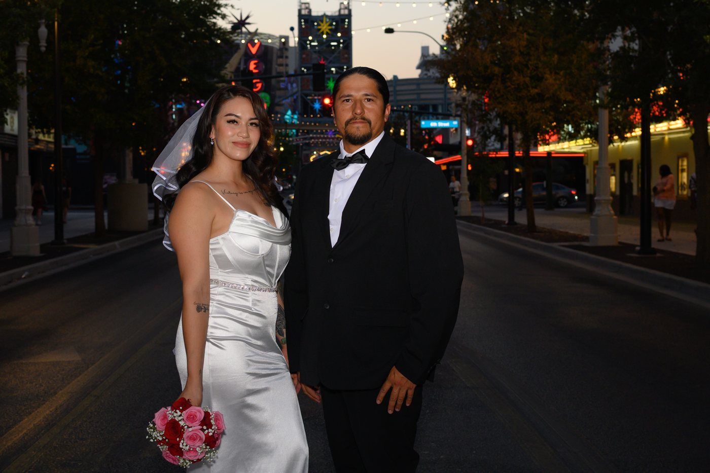 Bride and groom on Fremont Street with the Vegas neon sign behind them