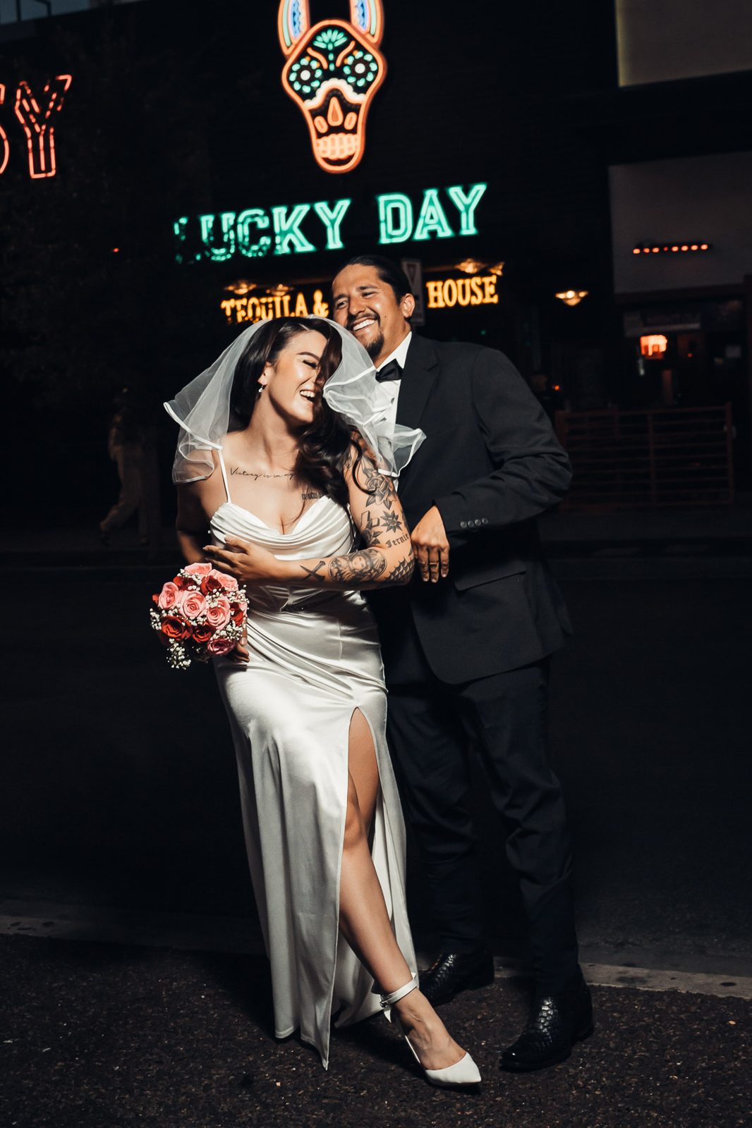 Couple laughing under downtown neon
