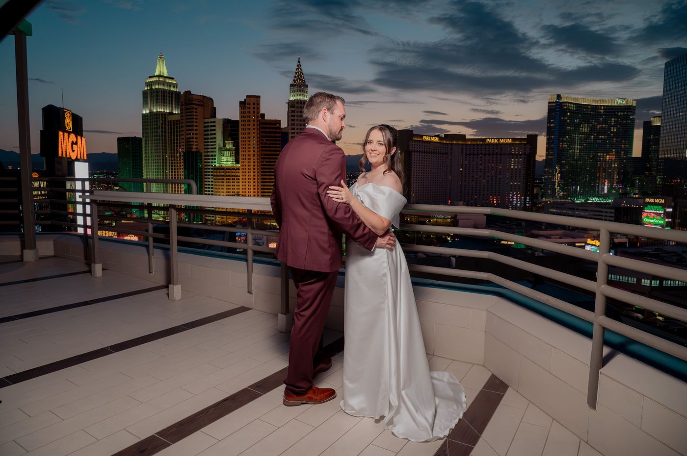 Bride and groom embrace with the Las Vegas Strip skyline behind them