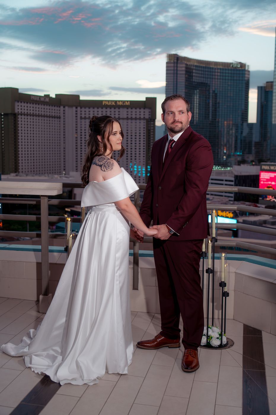 Bride and groom hold hands by candlelight with Park MGM behind them