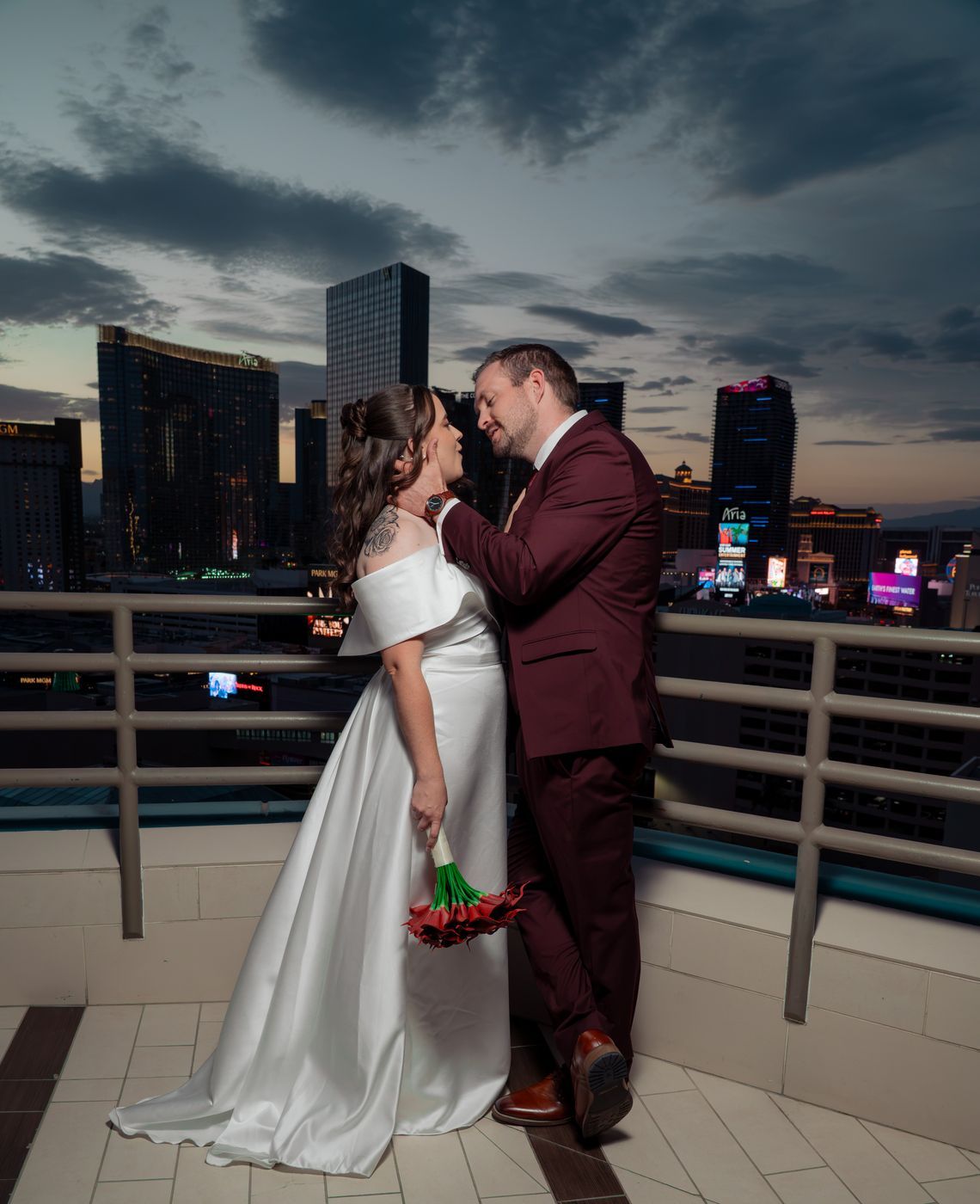 Bride and groom about to kiss against the twilight skyline