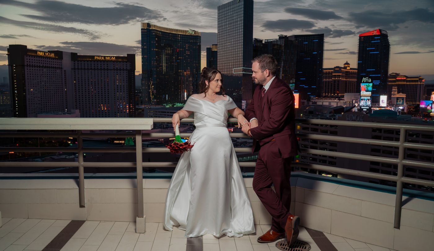 Bride and groom by the terrace rail with Park MGM and Aria behind