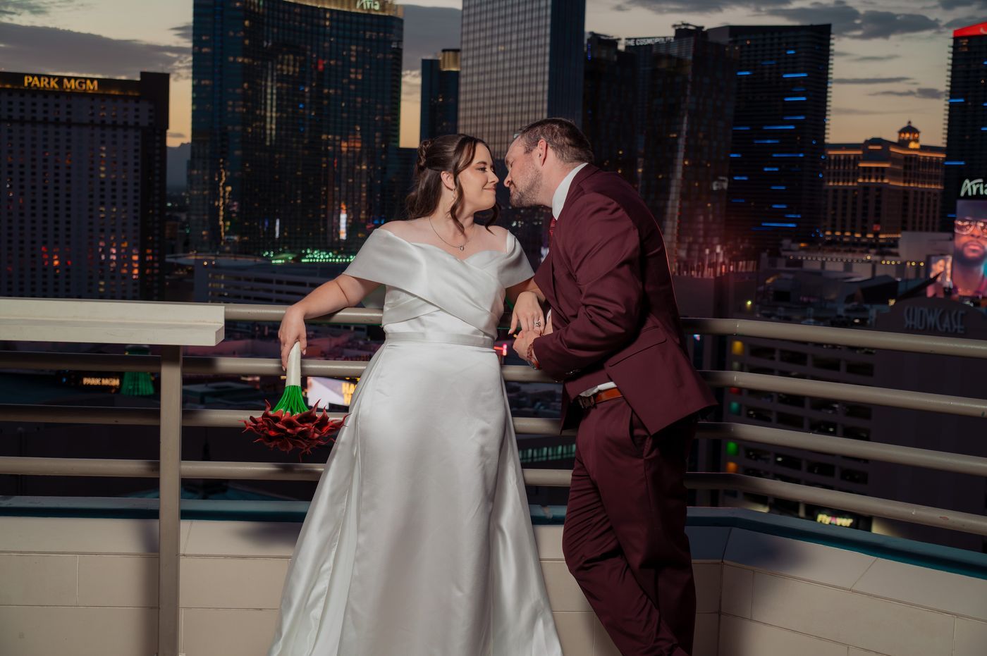 Bride and groom lean in for a kiss at the terrace rail