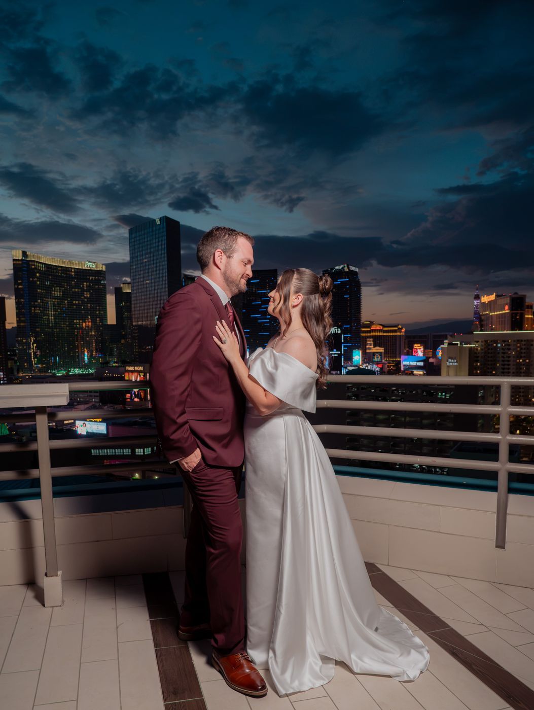 Bride and groom forehead to forehead against the night skyline