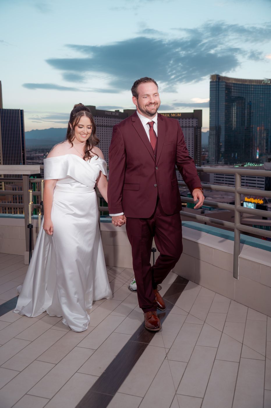 Bride and groom walk hand in hand along the terrace