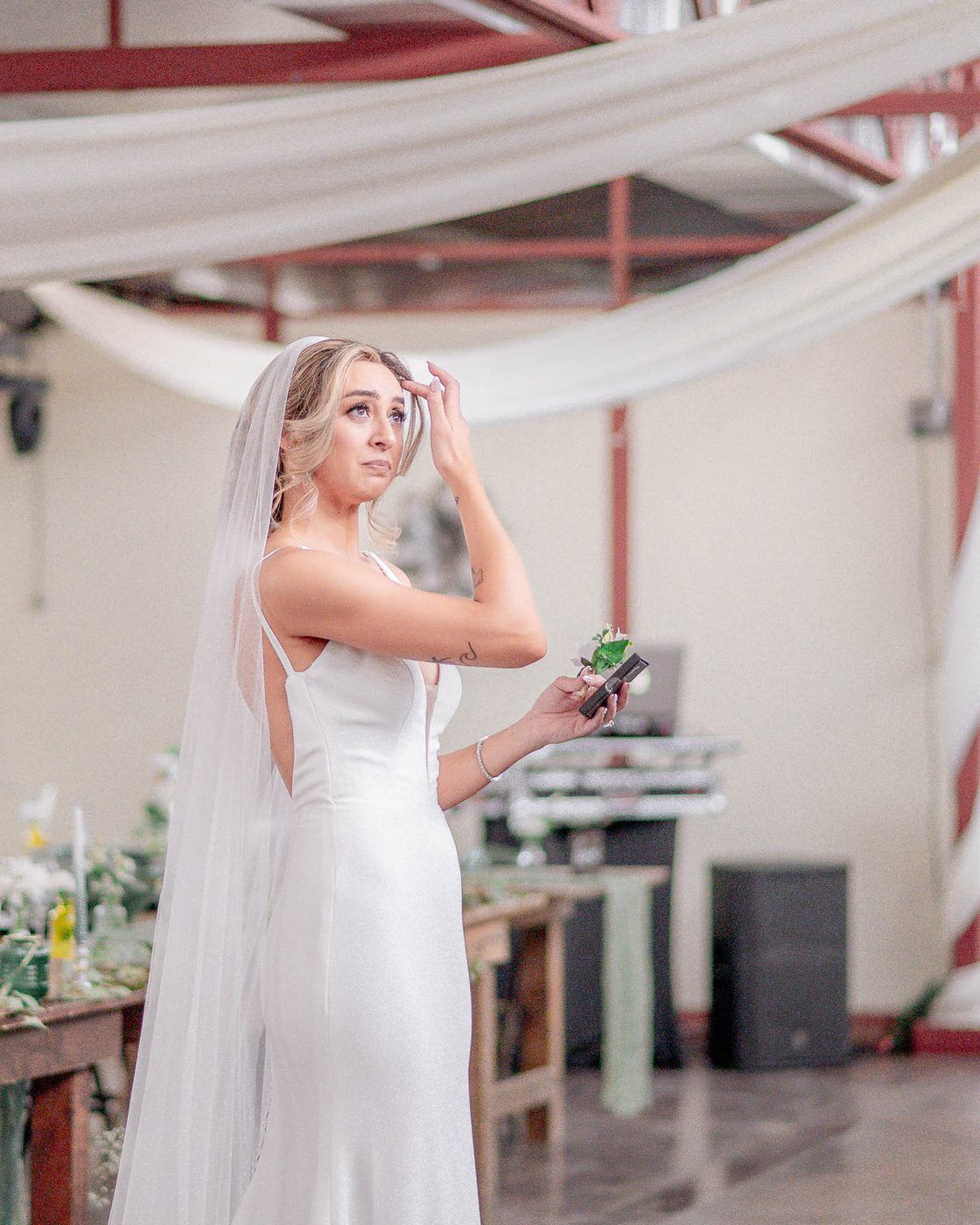 Bride holding a boutonniere before the ceremony