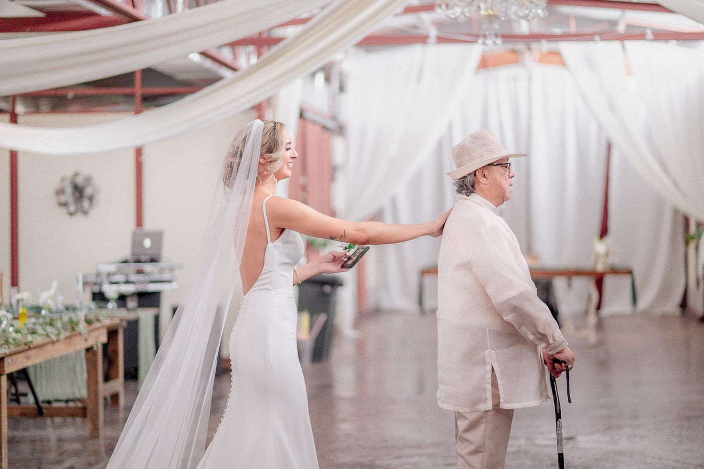 Bride reaching for her father's shoulder during their first look